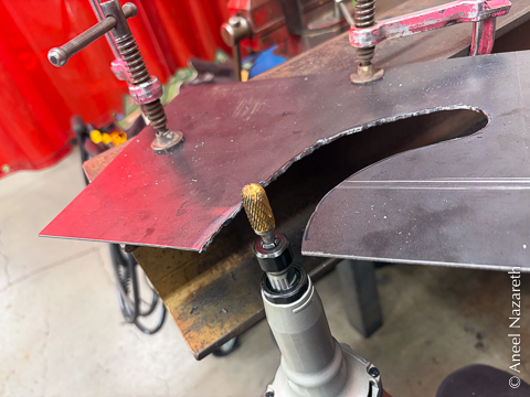 A die grinder bit is being used to clean up the rough plasma cut edge